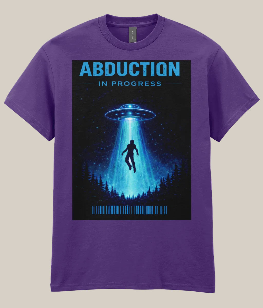 Purple t-shirt with a graphic of a UFO and silhouette under a beam of light, labeled 'Abduction in Progress' on a white background.
