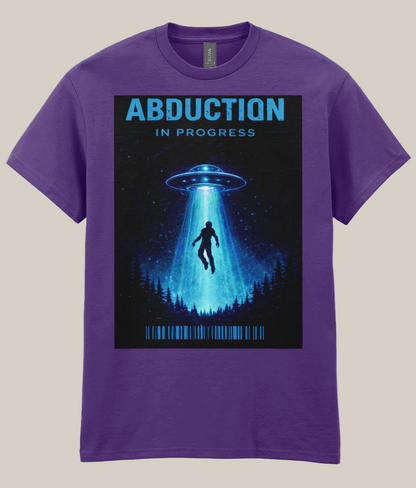 Purple t-shirt with a graphic of a UFO and silhouette under a beam of light, labeled 'Abduction in Progress' on a white background.
